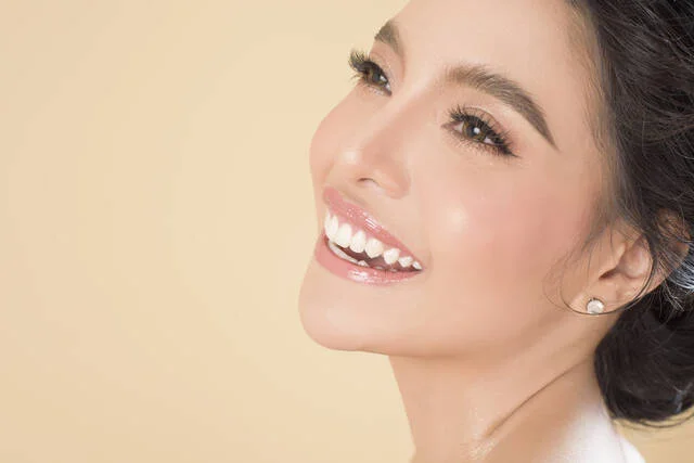 Close-up of a smiling woman's face and neck