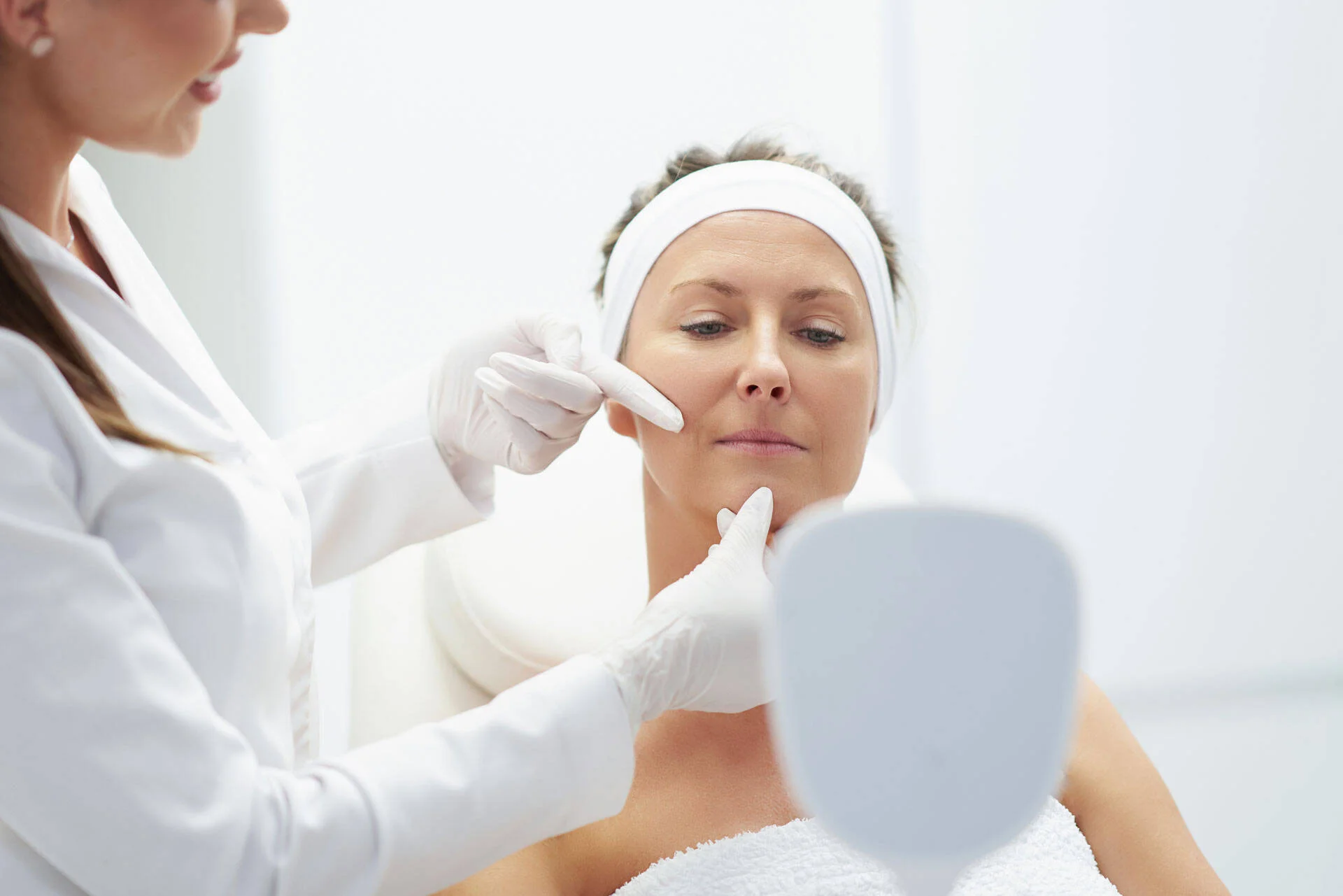 Practitioner examining a patient's face during a consultation