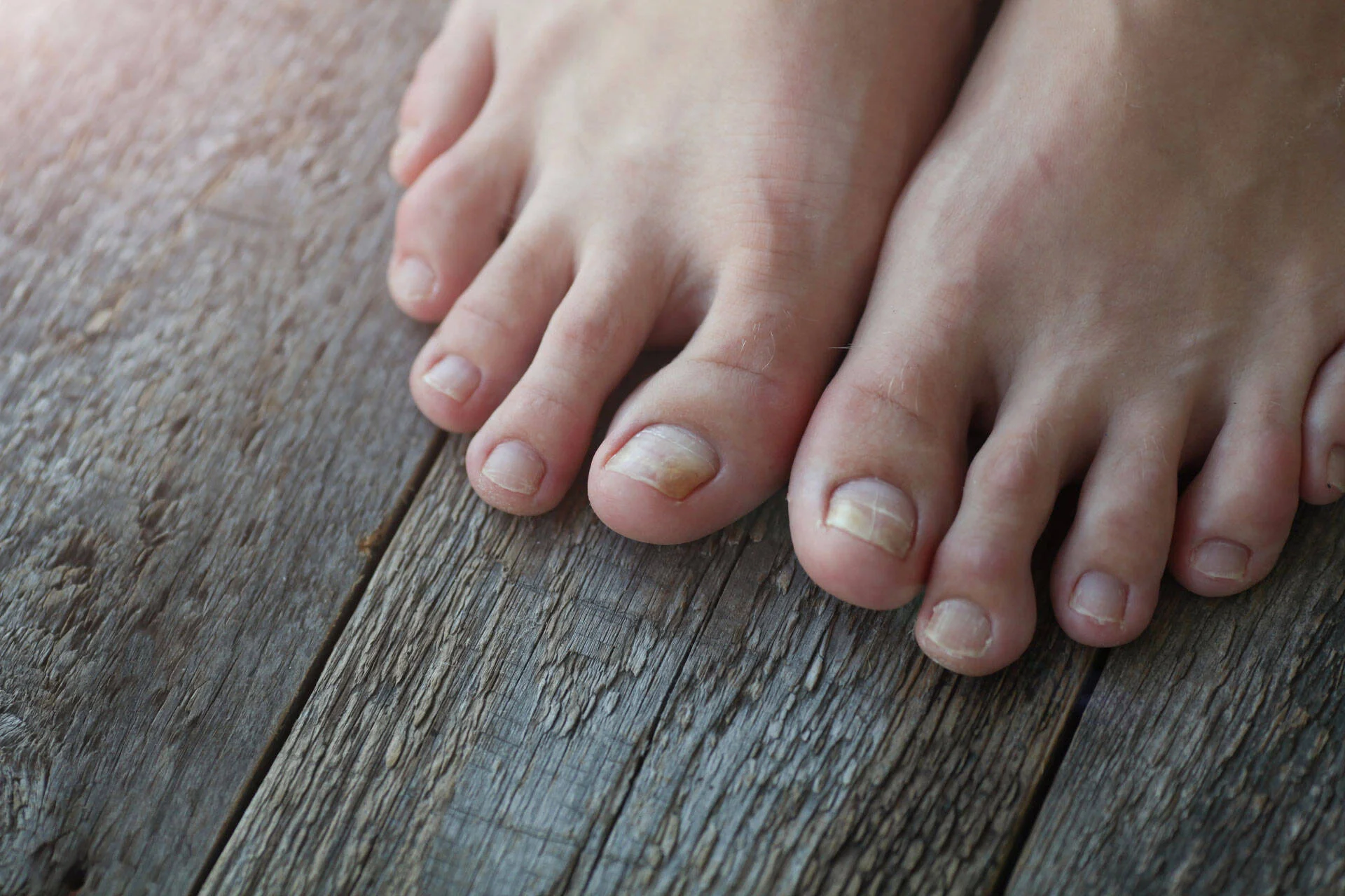 Close-up of bare feet on a wooden surface