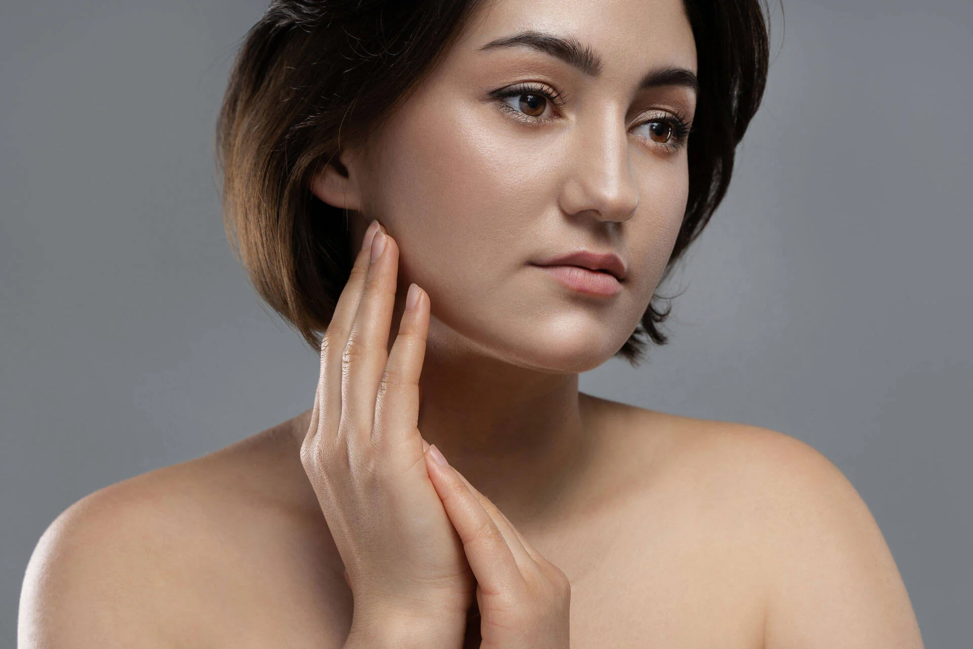Woman gently touching her cheek as part of a skincare routine